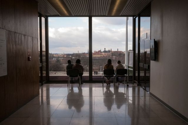 Ukrainian refugees look from a window in the regional assistance centre in Prague