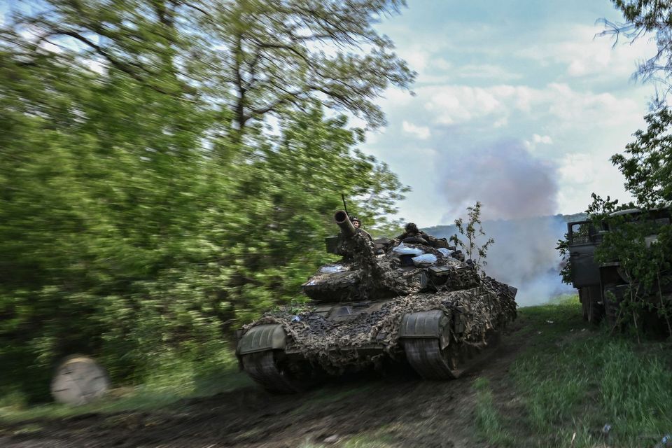 Ukrainian service members operate a tank at a front line position near the city of Lysychansk